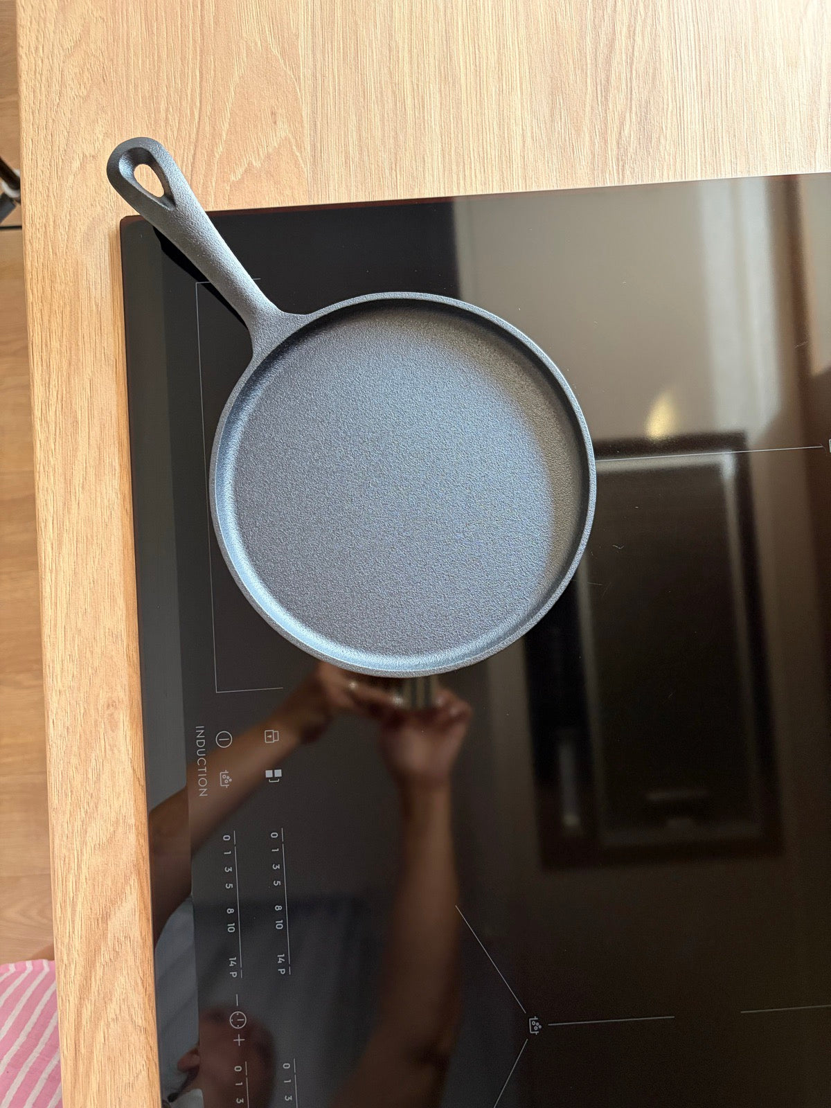 Lespede de fontă cu mâner, preîncălzită pe plita cu inducție, înainte de pancakes